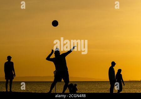 Silhouettes de Beach-volley au coucher du soleil jaune Banque D'Images