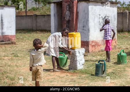 Les élèves se latrines se lavent les mains sur le chemin de l'école Banque D'Images