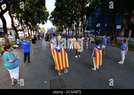 Tarragone, Espagne. 10 avril 2020. Un groupe de manifestants avec des drapeaux pro-indépendantistes garde une distance de sécurité pendant la manifestation.pendant la Journée nationale de Catalogne, Environ un millier de personnes avec des masques et des drapeaux pro-indépendance exigent l'indépendance de la Catalogne dans une manifestation ordonnée avec la distance de sécurité appropriée en raison de la crise sanitaire Covid-19 dans la rue Rambla Nova de Tarragone. Crédit : Ramon Costa/SOPA Images/ZUMA Wire/Alamy Live News Banque D'Images