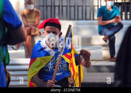 Tarragone, Espagne. 10 avril 2020. Un manifestant portant un masque facial comme mesure préventive porte un drapeau d'indépendance pendant la manifestation.pendant la Journée nationale de Catalogne, Environ un millier de personnes avec des masques et des drapeaux pro-indépendance exigent l'indépendance de la Catalogne dans une manifestation ordonnée avec la distance de sécurité appropriée en raison de la crise sanitaire Covid-19 dans la rue Rambla Nova de Tarragone. Crédit : Ramon Costa/SOPA Images/ZUMA Wire/Alamy Live News Banque D'Images