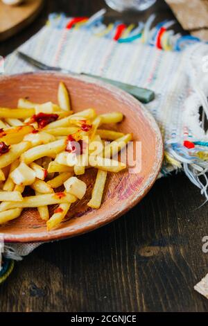 Frites de la poutine sur la surface noire. Plat canadien avec pommes de terre, fromage et sauce Banque D'Images