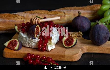 Foyer sélectif de camembert cuit au four avec des noix, du miel et des figues. Banque D'Images