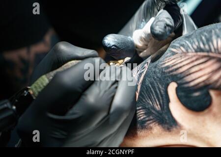 Image de maître faisant tatouage noir de serpent pour la femme Banque D'Images