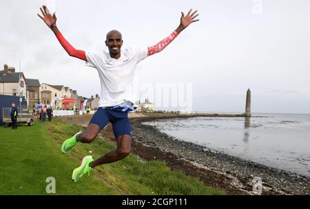 Sir Mo Farah après avoir traversé la ligne d'arrivée après avoir participé au semi-marathon de la côte d'Antrim. Le quatre fois médaillé d'or olympique a rejoint une équipe d'élite à Larne, dans le comté d'Antrim, après avoir accepté une invitation de l'organisateur de course James McIlroy. Banque D'Images