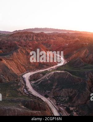 Montagnes de grès rouge de différents minéraux avec une route en premier plan, Zhangye Danxia Geopark, Chine Banque D'Images