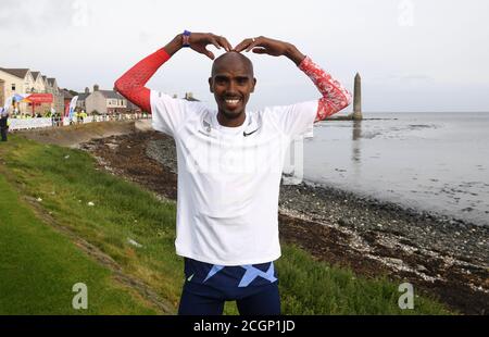 Sir Mo Farah après avoir traversé la ligne d'arrivée après avoir participé au semi-marathon de la côte d'Antrim. Le quatre fois médaillé d'or olympique a rejoint une équipe d'élite à Larne, dans le comté d'Antrim, après avoir accepté une invitation de l'organisateur de course James McIlroy. Banque D'Images