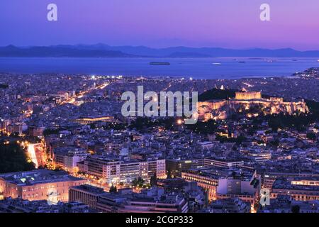 Vue panoramique nocturne d'Athènes et de l'Acropole prise de vue depuis la colline du Lycabette au crépuscule. Parthénon et Erechtheion illuminés par de superbes lumières de nuit. Saronique Banque D'Images