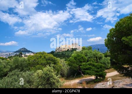Vue emblématique de la colline de l'Acropole et de la colline du Lycabette en arrière-plan à Athènes, Grèce depuis la colline de Pnyx en été, avec de grands nuages dans le ciel bleu. Banque D'Images