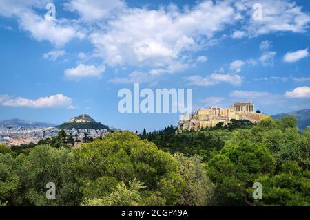 Vue emblématique de la colline de l'Acropole et de la colline du Lycabette en arrière-plan à Athènes, Grèce depuis la colline de Pnyx en été, avec de grands nuages dans le ciel bleu. Banque D'Images