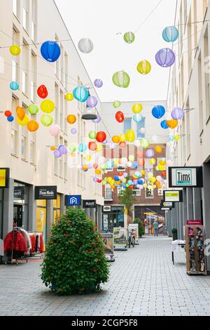 Lanternes en papier colorées au-dessus d'une rue commerçante dans le centre moderne d'une ville hollandaise. Banque D'Images