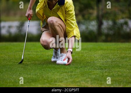 Le golfeur de fille se prépare pour frapper le fer pendant l'entraînement de golf Banque D'Images