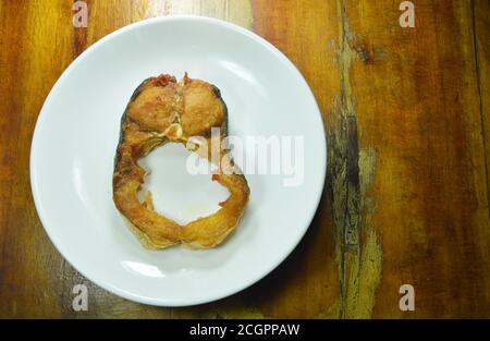 tranche de poisson-chat rayé salé frit sur une assiette blanche Banque D'Images