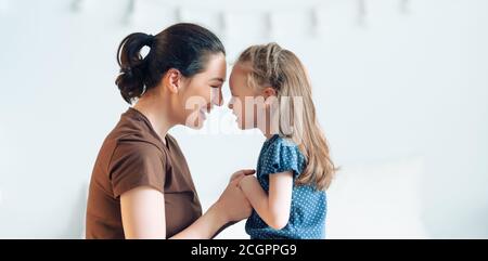 Une belle petite fille et sa mère aiment le soleil matin. Bon séjour à la maison. Banque D'Images