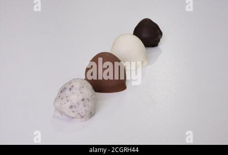 framboises trempées ou recouvertes de chocolat en moule coupé en deux. Différentes saveurs : chocolat blanc, chocolat au lait, chocolat noir et biscuits Banque D'Images