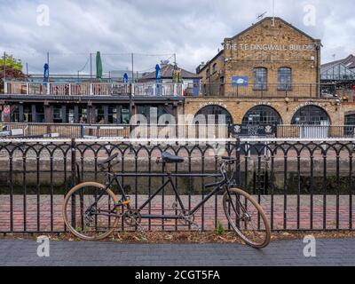 Un vélo tandem enchaîné aux rails à Hampstead Road Lock Sur le canal Regents avec Camden Lock Market dans le arrière-plan un lieu de vacances touristique populaire Banque D'Images