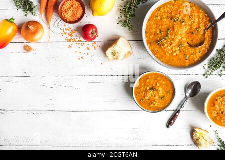 Soupe de gentil rouge avec légumes sur fond blanc, vue de dessus, espace de copie. Soupe traditionnelle turque ou arabe de lentilles et de légumes épicés, légumes sains Banque D'Images