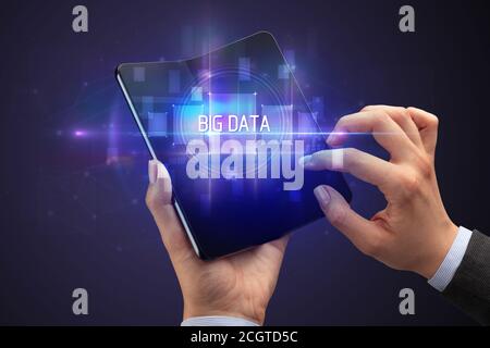 Businessman holding un smartphone avec le BIG DATA, la nouvelle technologie d'inscription concept Banque D'Images