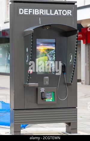 Un défibrillateur ou un DAE dans un boîtier téléphonique situé dans une rue de grande hauteur, route commerciale, Portsmouth Banque D'Images