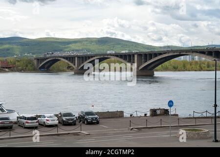 Vue sur le pont communal de Krasnoyarsk (1961) et sur la jetée avec des voitures garées depuis la rue Dubrovinsky depuis la rive gauche. Russie. Banque D'Images