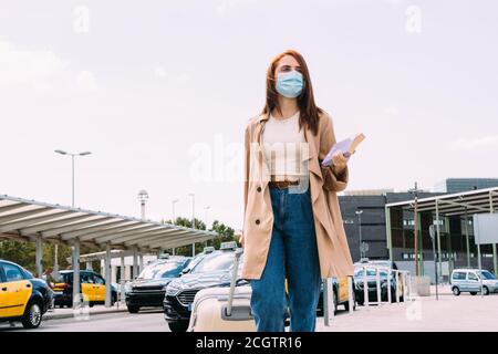 une jeune femme avec ses bagages arrive à la gare par cabine Banque D'Images