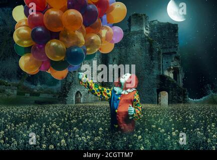 un clown tient beaucoup de ballons contre un creepy arrière-plan Banque D'Images