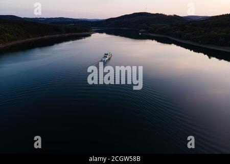 Attendorn Wamge, Allemagne. 12 septembre 2020. Une excursion en bateau sur le lac Bigge laisse des vagues dans l'eau. Les météorologues continuent de prévoir un temps chaud et ensoleillé pour les jours à venir. En raison de la sécheresse qui a duré tout l'été, le niveau d'eau de nombreux réservoirs est actuellement très bas. (Tir de drone) Credit: Jonas Güttler/dpa/Alay Live News Banque D'Images