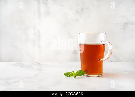 Une tasse de thé en verre sur fond blanc avec espace de copie. Concept de boissons chaudes Whinter Banque D'Images