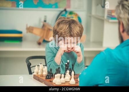 Garçon pense ou plan au jeu d'échecs, style vintage pour le concept d'éducation. Enfant jouant aux échecs enfant et enfance. Banque D'Images