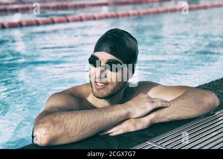 Natation athlète homme portant des lunettes de sport et une casquette en intérieur piscine Banque D'Images