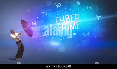 Homme d'affaires se défendant avec le parapluie de la cyber-attaque et de L'inscription DE LA CYBER-CRIMINALITÉ, concept de sécurité en ligne Banque D'Images