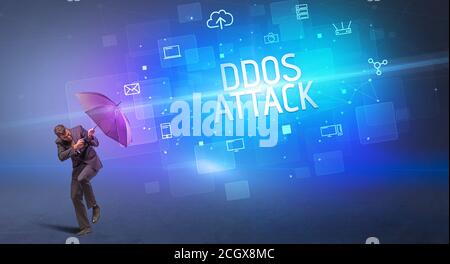 Homme d'affaires se défendant avec le parapluie de la cyber-attaque et de L'inscription D'ATTAQUE DDOS, concept de sécurité en ligne Banque D'Images