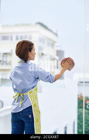 Femme nettoyant la grande fenêtre Banque D'Images