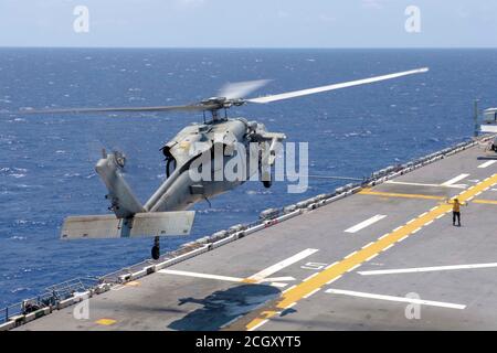 MER DE CHINE MÉRIDIONALE (SEPT 5, 2020) un hélicoptère MH-60S Sea Hawk affecté aux Archanges de l'Escadron de combat de la mer (HSC) 25 le détachement 6 se prépare à atterrir sur le pont de vol du navire d'assaut amphibie déployé par l'avant USS America (LHA 6). L'Amérique, navire chef de file du America Amphiobie Ready Group, affecté au Squadron amphibie 11, avec la 31e unité expéditionnaire maritime, Opère dans la zone de responsabilité de la 7e flotte des États-Unis afin d'améliorer l'interopérabilité avec les alliés et les partenaires et de servir de force d'intervention prête à l'emploi pour défendre la paix et la stabilité dans la région Indo-Pacifique. (ÉTATS-UNIS Banque D'Images