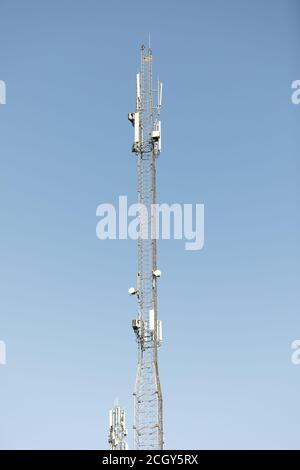 Mât ou tour pour la communication par téléphone mobile sous un soleil éclatant et dans un ciel bleu. Relais tour Internet 4G Banque D'Images