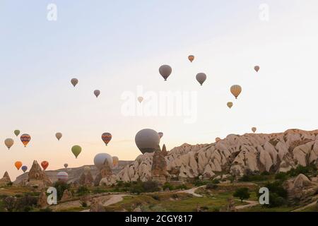 De nombreux ballons d'air chaud volant au-dessus des rochers de Cappadoce en Turquie. Banque D'Images