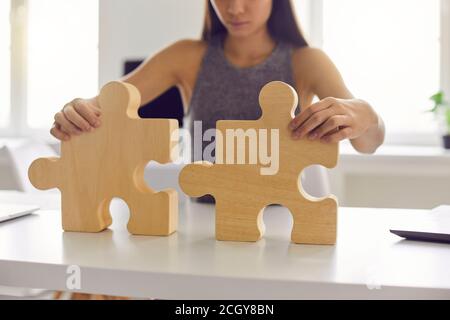 Femme d'affaires debout et essayant de faire toute l'image à partir de les détails en bois se casse dans le bureau Banque D'Images