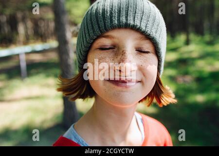 Gros plan d'une jeune fille ravie souriante à l'intérieur une forêt avec les yeux fermés Banque D'Images