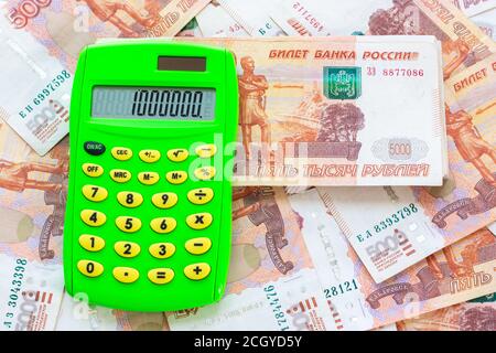 Le numéro 1,000,000 est écrit sur la calculatrice, la calculatrice se trouve sur un tas d'argent Banque D'Images