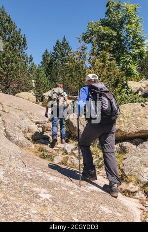 Photo d'un couple senior en randonnée dans la montagne ensemble par temps ensoleillé Banque D'Images
