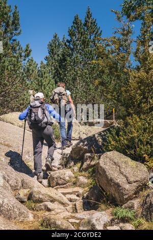 Photo d'un couple des années 60 trekking dans la montagne ensemble par temps ensoleillé Banque D'Images
