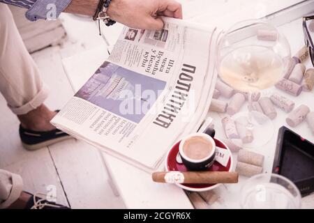 Un homme dans un café lit un journal et des boissons café Banque D'Images