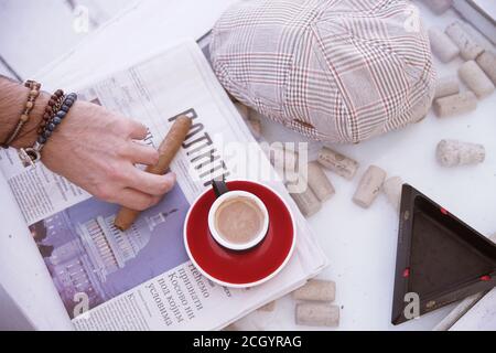 Un homme dans un café lit un journal et des boissons café Banque D'Images