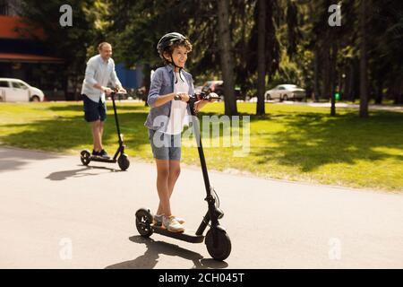 Un homme heureux avec papa qui a fait un tour sur un scooter électrique Banque D'Images