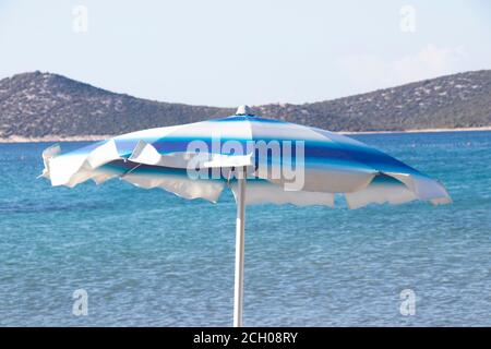 Parasols de plage rayés bleus dans le vent, détail Banque D'Images