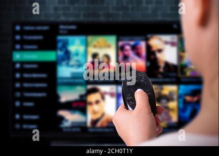 Concept de diffusion multimédia. Télécommande à main femelle. Concept de fournisseur de contenu VOD Banque D'Images