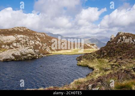 Llyn Cerrig y Myllt petit lac de montagne sur les pentes de Cnicht avec Glyders à distance dans le parc national de Snowdonia. Gwynedd, pays de Galles, Royaume-Uni, Grande-Bretagne Banque D'Images