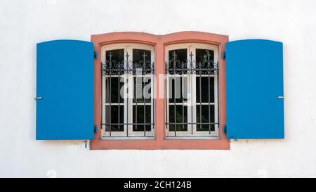 Ancienne fenêtre avec treillis décoratif et volets ouverts Banque D'Images