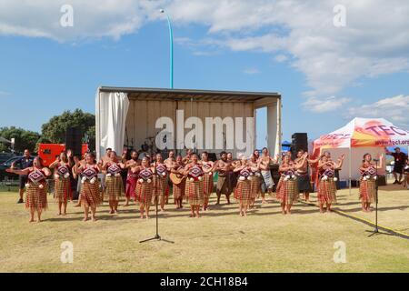 Une représentation de kapa haka (danse de groupe) par des hommes et des femmes maoris en costume traditionnel. Mont Maunganui, Nouvelle-Zélande Banque D'Images