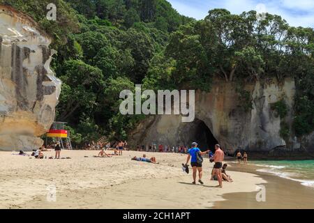 Cathedral Cove, Nouvelle-Zélande. Une foule de touristes sur la plage en face de la célèbre arcade naturelle de roche Banque D'Images