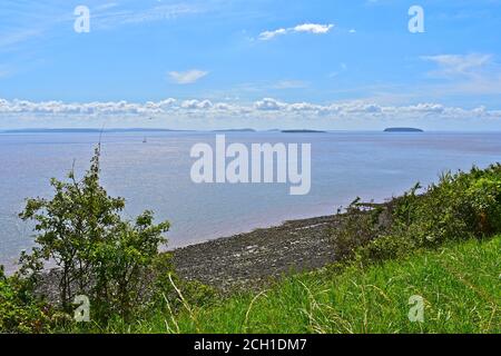 Belle vue sur le canal de Bristol depuis le chemin Penarth Clifftop avec plage et île lointaine de Flat Holm et Steep Holm. Yacht à voile à distance. Banque D'Images